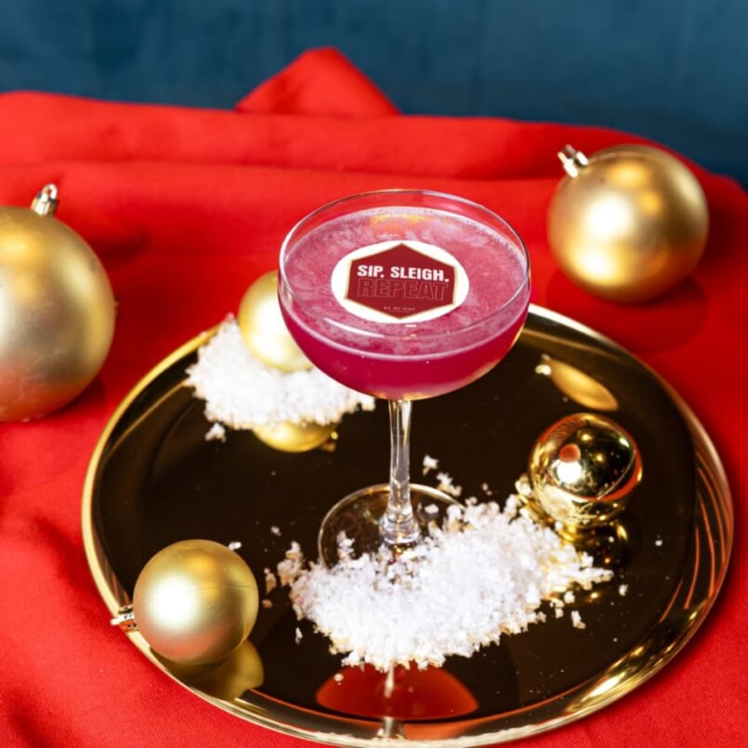 Red cocktail in coupe glass on a tray